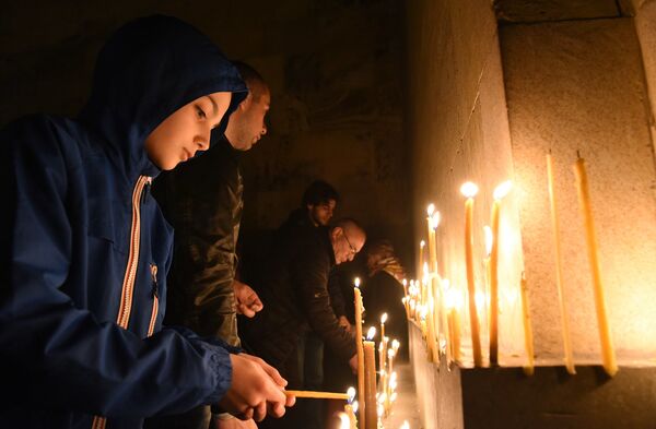 Обычно свечи не зажигают у стен собора, но дни больших православных праздников и особенно Пасха - это исключение из правил - Sputnik Грузия