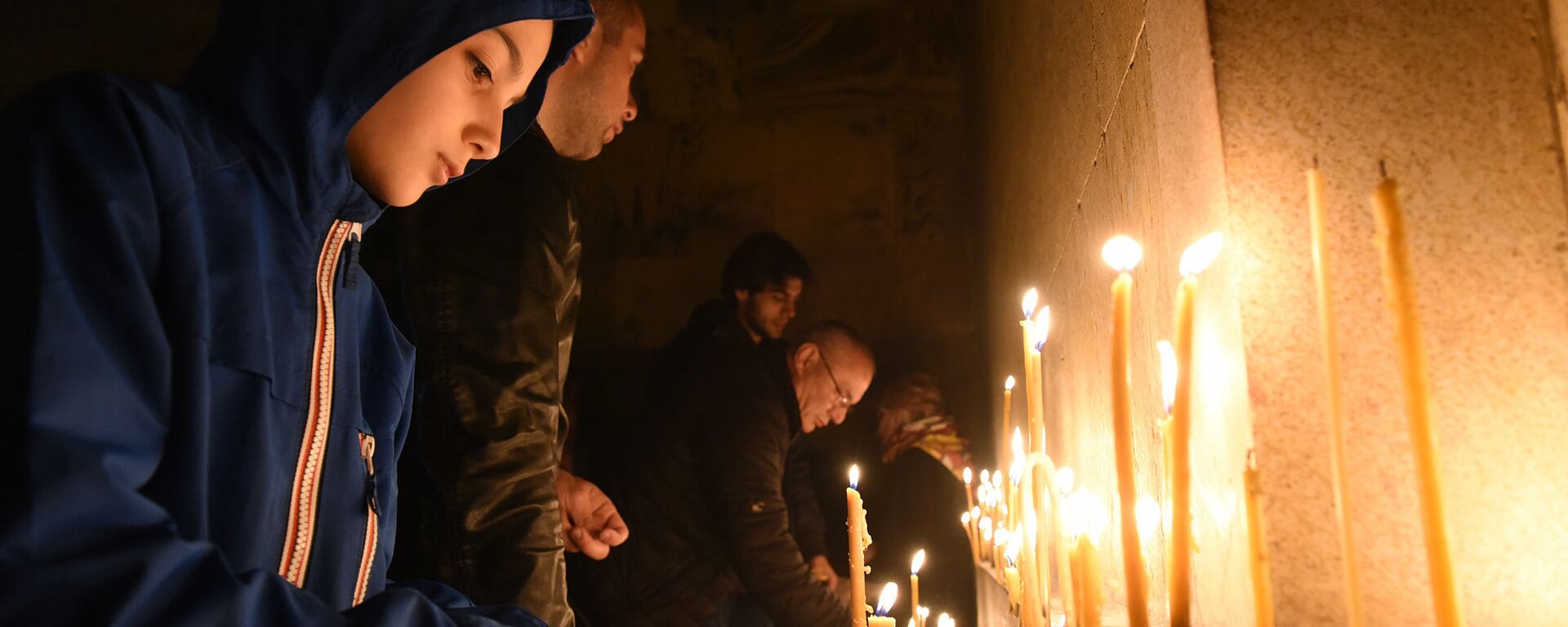 Верующие зажигают свечи во время Пасхального богослужения у стен храма Святой Троицы - Sputnik Грузия, 1920, 28.04.2021