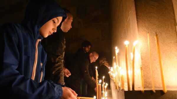 Верующие зажигают свечи во время Пасхального богослужения у стен храма Святой Троицы - Sputnik Грузия