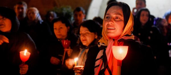 Верующие с горящими свечами во время Пасхального богослужения у стен храма Святой Троицы - Sputnik Грузия