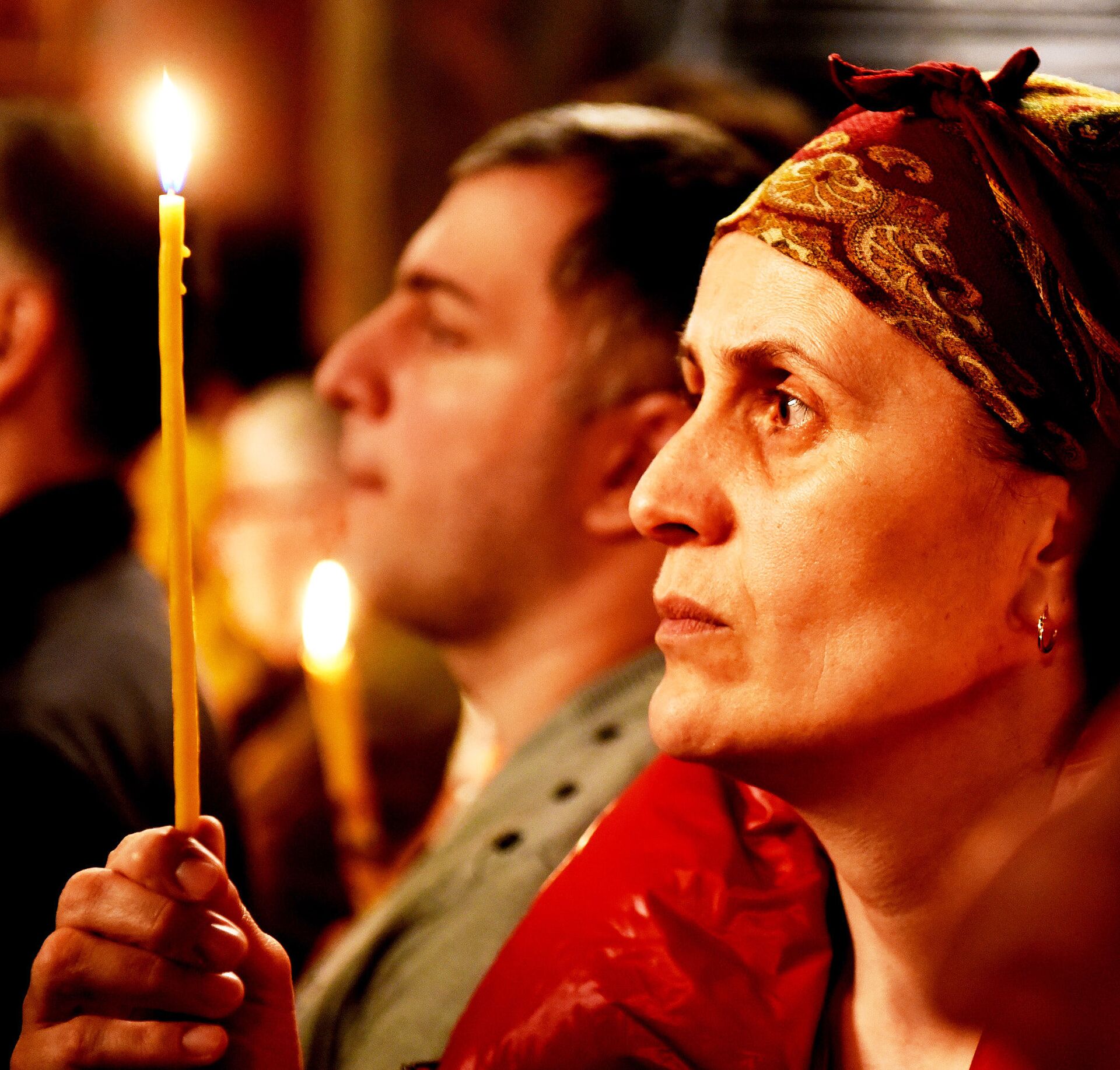 Верующие с горящими свечами во время Пасхального богослужения у стен храма Святой Троицы - Sputnik Грузия, 1920, 21.04.2022