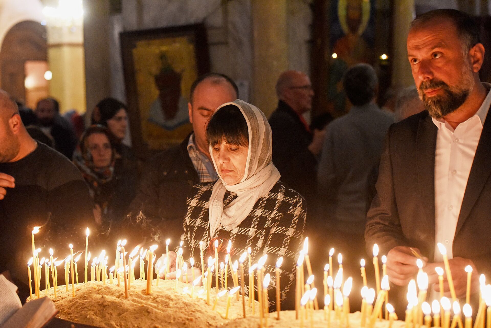 Верующие зажигают свечи во время Пасхального богослужения в храме Святой Троицы - Sputnik Грузия, 1920, 24.08.2021