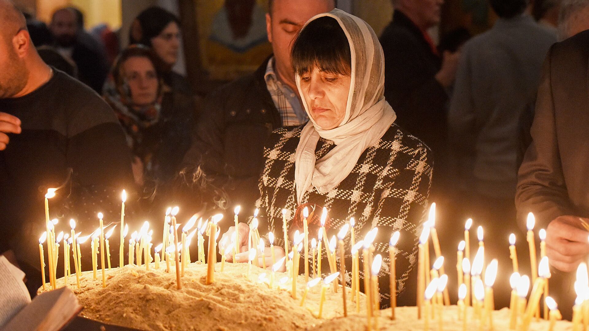 Верующие зажигают свечи во время Пасхального богослужения в храме Святой Троицы - Sputnik Грузия, 1920, 01.05.2022