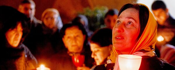 Верующие с горящими свечами во время Пасхального богослужения у стен храма Святой Троицы - Sputnik Грузия