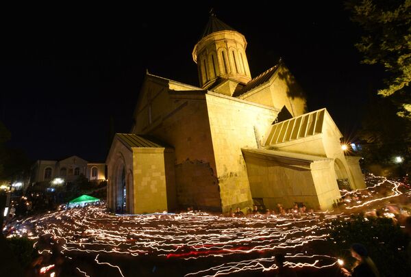 Верующие с горящими свечами обходят крестным ходом тбилисский кафедральный собор Святой Троицы - Самеба, во время Пасхального богослужения - Sputnik Грузия