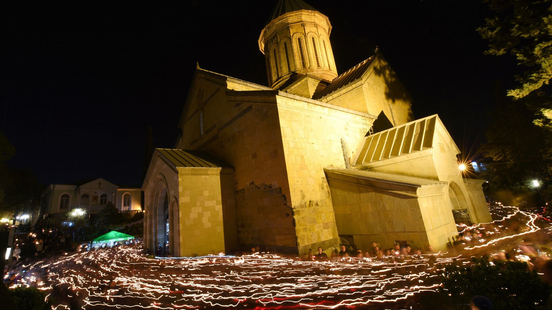 Верующие с горящими свечами во время Пасхального богослужения у стен храма Святой Троицы - Sputnik Грузия, 1920, 05.01.2022