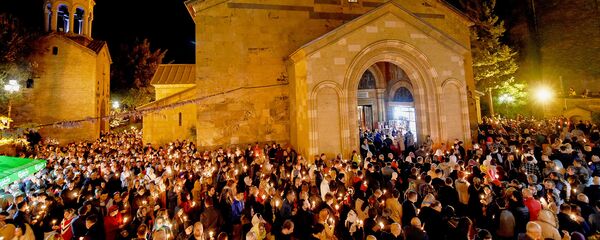 Верующие с горящими свечами во время Пасхального богослужения у стен храма Святой Троицы - Sputnik Грузия