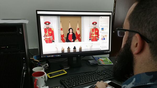Человек за компьютером смотрит на официальную страницу Саломе Зурабишвили в соцсети Facebook - Sputnik Грузия