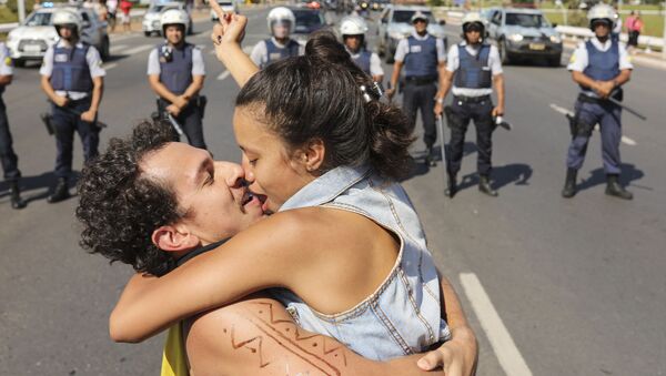 Пара целуется напротив заслона полиции во время забастовки Национального союза студентов в Бразилии - Sputnik Грузия