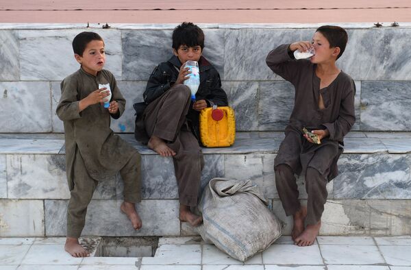 Афганские мальчики пьют напиток на основе йогурта во внутреннем дворе Голубой мечети в городе Мазари-Шариф во время Рамадана - Sputnik Грузия