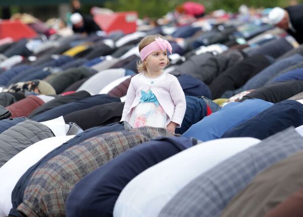 Маленькая девочка смотрит, как албанские мусульмане читают утренние молитвы Ид аль-Фитра, посвященные окончанию священного месяца Рамадан на площади Скандербег в Албании - Sputnik Грузия