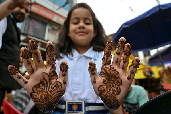 Девочка показывает руки, покрытие хной до начала празднования Ид-аль-Фитра в Шринагаре - Sputnik Грузия