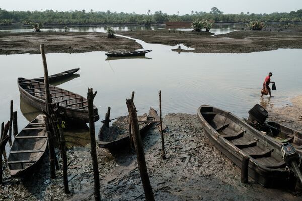 ნიგერიელი მეთევზე  დაბინძურებულ მდინარესთან - Sputnik საქართველო