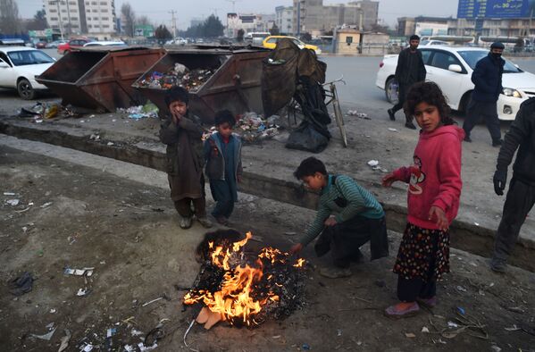 Афганские дети жгут пластик, чтобы согреться у костра на обочине дороги в Кабуле - Sputnik Грузия