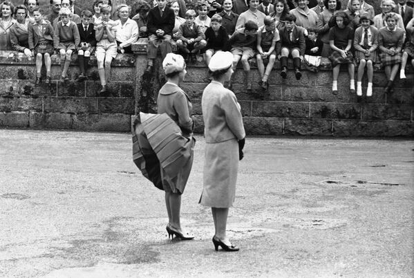 Игривый ветер поднял юбку принцессы Маргарет, пока она вместе с королевой Елизаветой II ждала прибытия президента США Дуайта Эйзенхауэра в замке Балморал в Шотландии - Sputnik Грузия