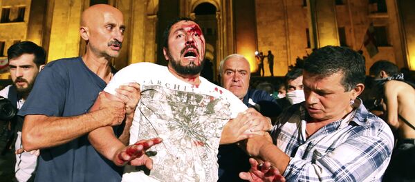 Пострадавшего уводят с митинга. Акция протеста у парламента Грузии - Sputnik Грузия