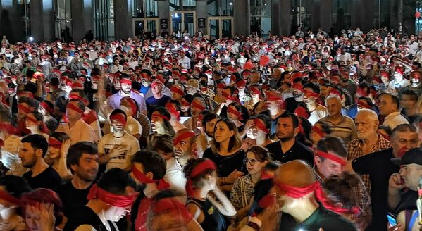 В ночь на четверг сотни митингующих у здания парламента одели на голову красные повязки - Sputnik Грузия