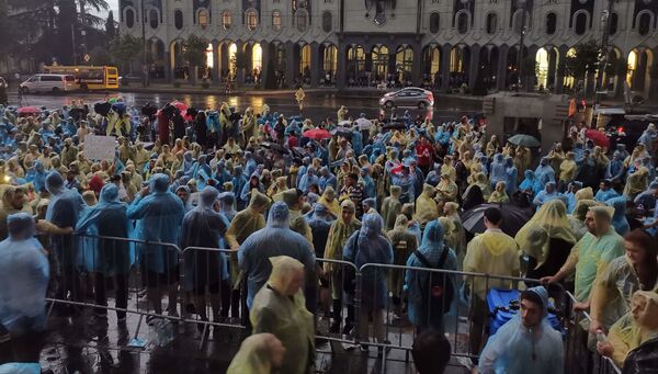 Хотя в дождь протестующих у здания парламента становится меньше, там все равно сотни человек - Sputnik Грузия