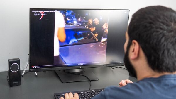 Пользователь смотрит на компьютере ролик про инцидент с Георгиевской ленточкой - Sputnik Грузия