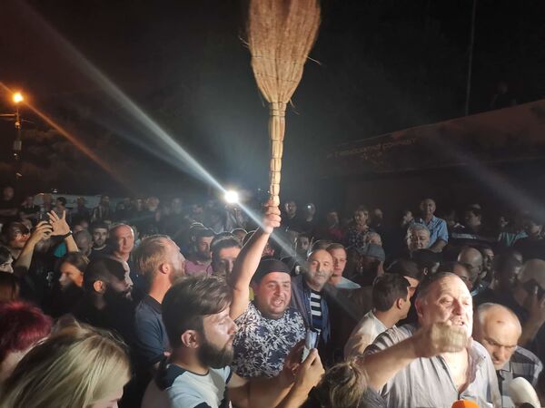 Некоторые из участников акции принесли с собой веники, как символ беспредела, и бросали их через ограждение во двор телекомпании - Sputnik Грузия
