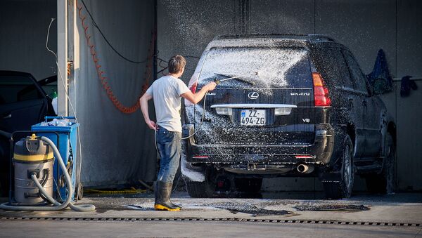 Автомойка. Мойщик распыляет чистящую пену на автомобиль Lexus - Sputnik Грузия