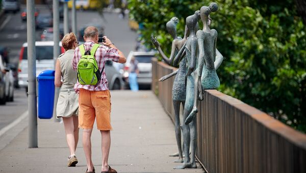 Туристы фотографируют статуи женщин на мосту Бараташвили. Городские достопримечательности - Sputnik Грузия