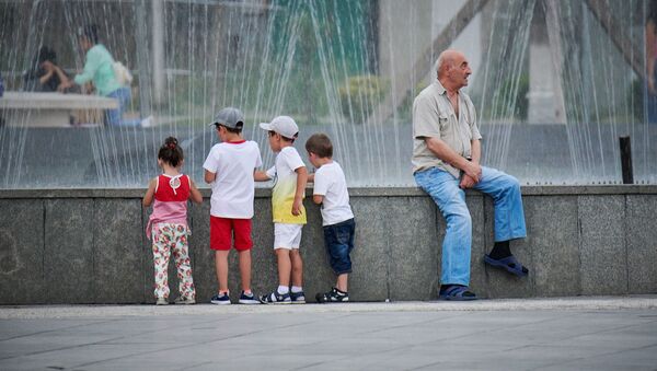 Пожилой мужчина с детьми сидит у фонтана в парке Рике - Sputnik Грузия