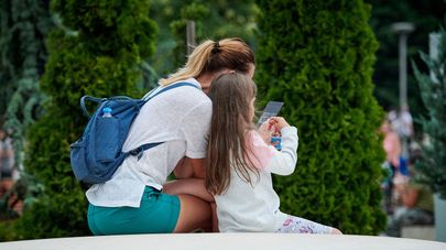 Женщина с ребенком читают сообщения в соцсети в смартфоне
