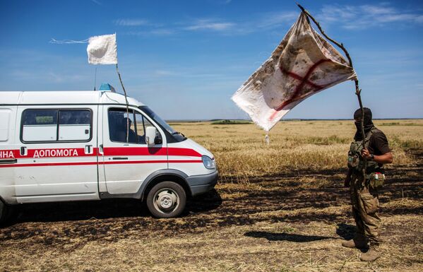 Украинский военный с белым флагом во время передачи убитых на нейтральной территории вблизи поселка Диброво в Донецкой области - Sputnik Грузия