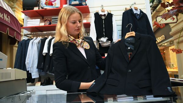 Продажа одежды в магазине. Молодая продавщица показывает товар - Sputnik Грузия