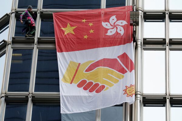 На транспаранте, который повесил на небоскребе французский экстремал, изображены флаги Китая и Гонконга с символическим рукопожатием - Sputnik Грузия