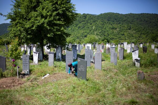 Уважение и забота о старых и память об ушедших предках - неотъемлемая часть жизни ущелья. Панкисские женщины бережно смотрят за могильными памятниками. На фото - женщина ухаживает за могилой на кладбище в селе Джоколо - Sputnik Грузия