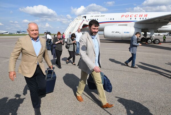 Кирилл Вышинский (в центре) и генеральный директор МИА Россия сегодня Дмитрий Киселев (слева) в аэропорту Внуково после прибытия туда самолета с россиянами - Sputnik Грузия