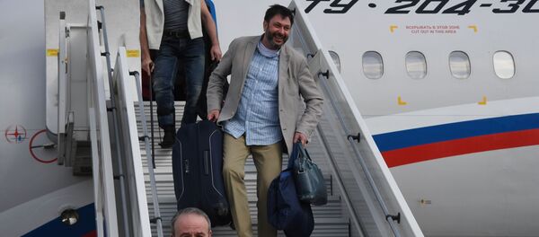 Руководитель портала РИА Новости Украина Кирилл Вышинский (в центре) спускается с борта российского самолета Ту-204 в аэропорту Внуково - Sputnik Грузия