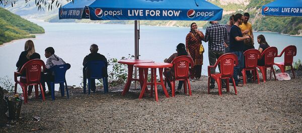 Туристы сидят на берегу Жинвальского водохранилища - Sputnik Грузия