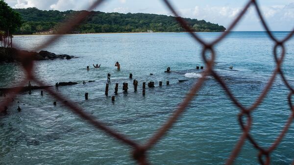 Вид сквозь решетку на купающихся людей в Никарагуа - Sputnik Грузия