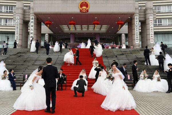 Молодожены на массовой свадьбе у здания городского правительства в преддверии 70-летия КНР - Sputnik Грузия