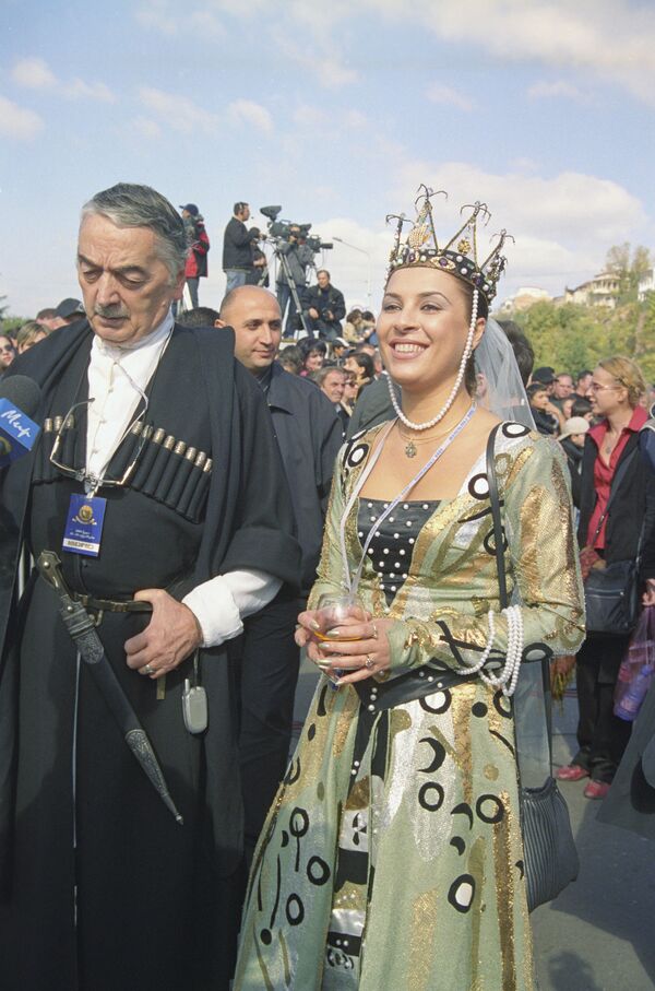 Известный грузинский кинокритик, профессор Георгий (Гоги) Долидзе в национальной одежде на празднике Тбилисоба в 2004 году. Рядом с ним девушка в костюме знаменитой царицы Тамар - Sputnik Грузия