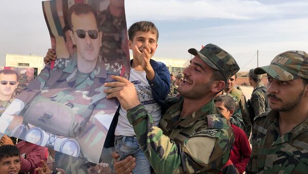 Дети и военнослужащие с плакатами с портретом президента Сирии Башара Асада в освобожденном сирийской правительственной армией городе Манбидж в Сирии - Sputnik Грузия