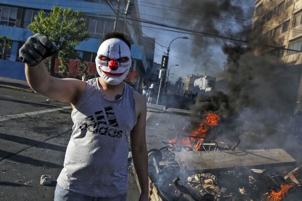 Демонстрант в маске во время протестов в Сантьяго, Чили - Sputnik Грузия