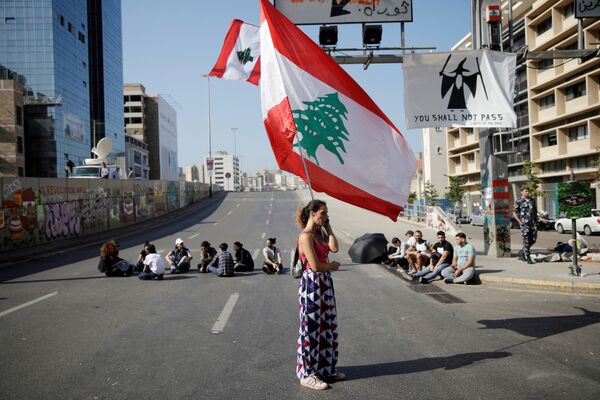 Женщина с флагом Ливана во время антиправительственных протестов в Бейруте - Sputnik Грузия