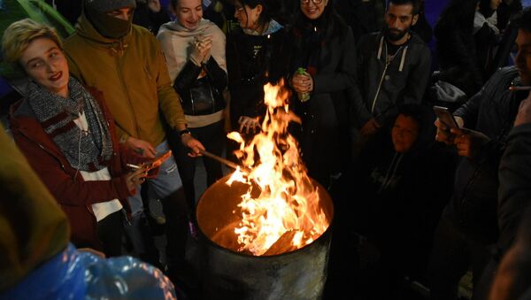 Участники акции протеста греются у огня у здания парламента Грузии 17 ноября 2019 - Sputnik Грузия