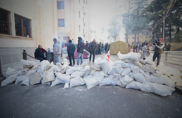Настоящая баррикада из мешков с песком перегораживает одну из улиц, ведущую ко входу в парламент - Sputnik Грузия