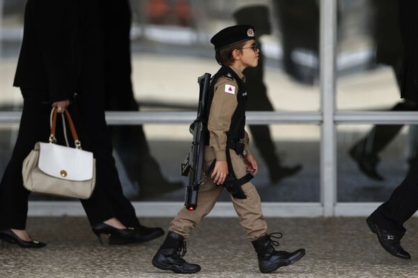 А в городе Бразилиа, столице Бразилии, маленький мальчик оделся в военную форму, чтобы посмотреть смену караула у президентского дворца - Sputnik Грузия