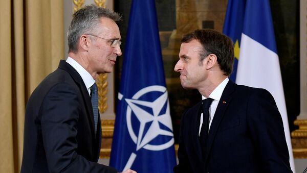 Генсек НАТО Йен Столтенберг и президент Франции Эммануэль Макрон жмут руки во время встречи в Елисейском дворце - Sputnik Грузия