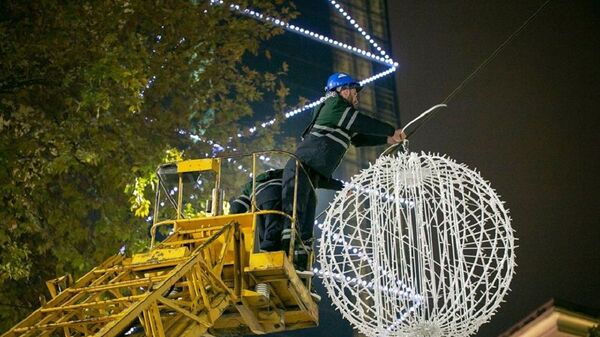 Столица Грузии готовится к Новому году. Рабочий мэрии монтирует новогоднюю иллюминацию - Sputnik Грузия
