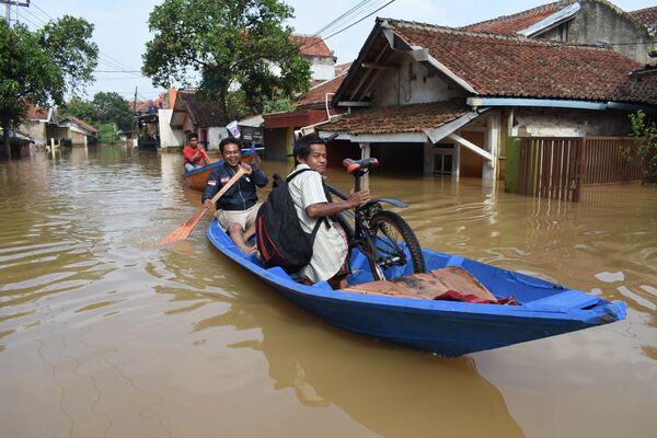 Жители на затопленной дороге в Дайехколоте, Индонезия. Наводнение в регионе и выход рек из берегов вызвали сильные дожди - Sputnik Грузия