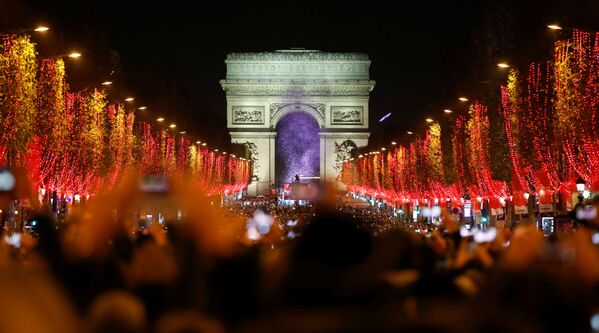 Зрители во время праздничного светового шоу перед Триумфальной аркой в Париже - Sputnik Грузия