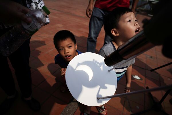 Дети наблюдают частичное солнечное затмение в Научно-образовательном центре в Бангкоке - Sputnik Грузия