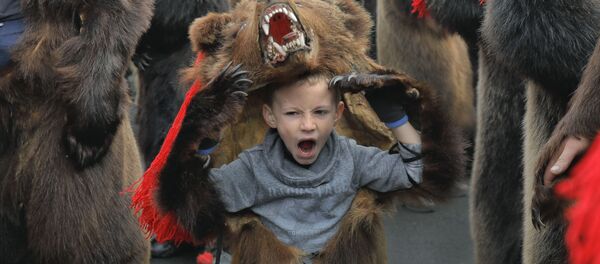 Зевающий мальчик в костюме медведя на новогоднем шествии в румынском городе Комэнешти Зевающий мальчик в костюме медведя на новогоднем шествии в румынском городе Комэнешти - Sputnik Грузия